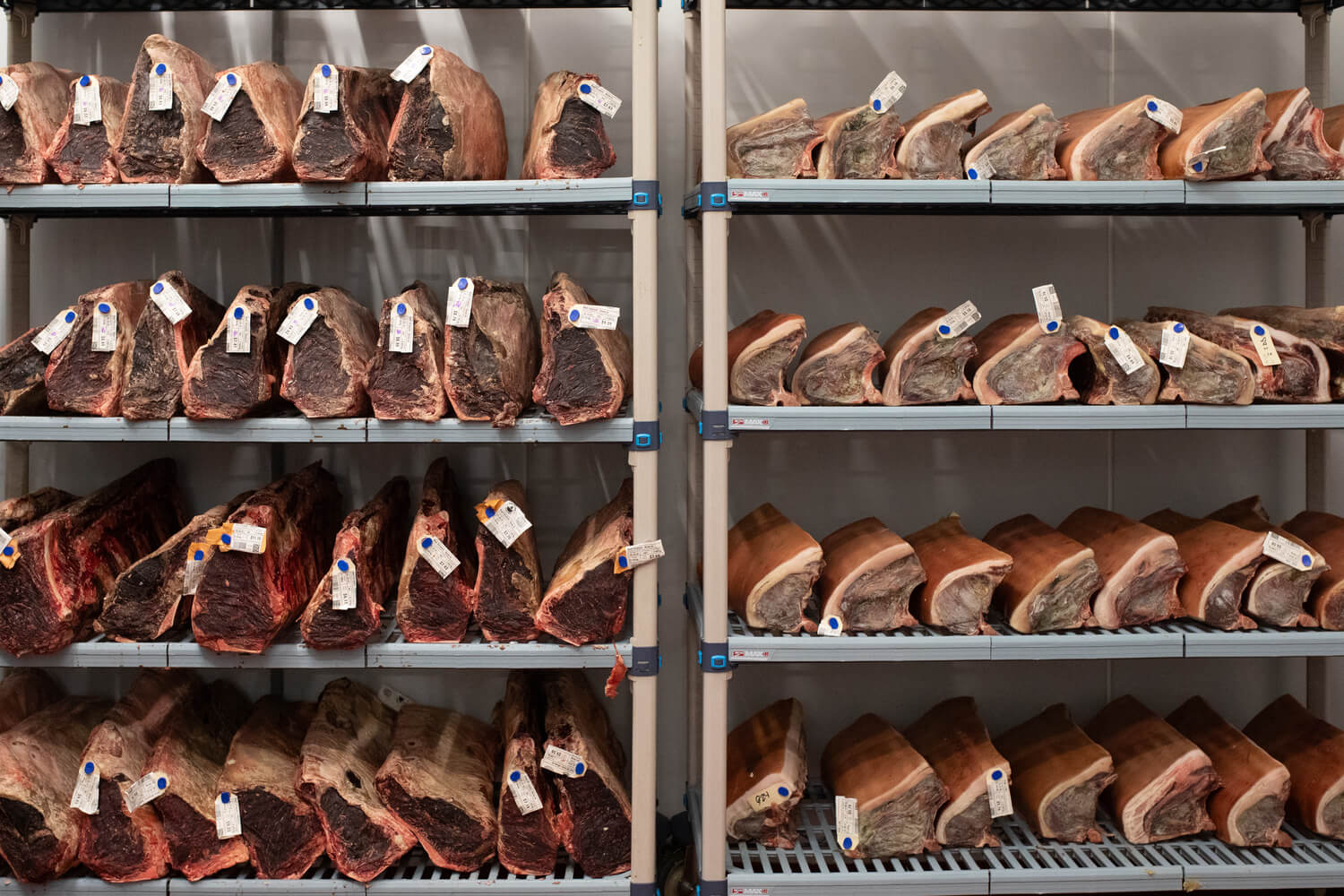 Shelves of meat cuts arranged in a storage room.